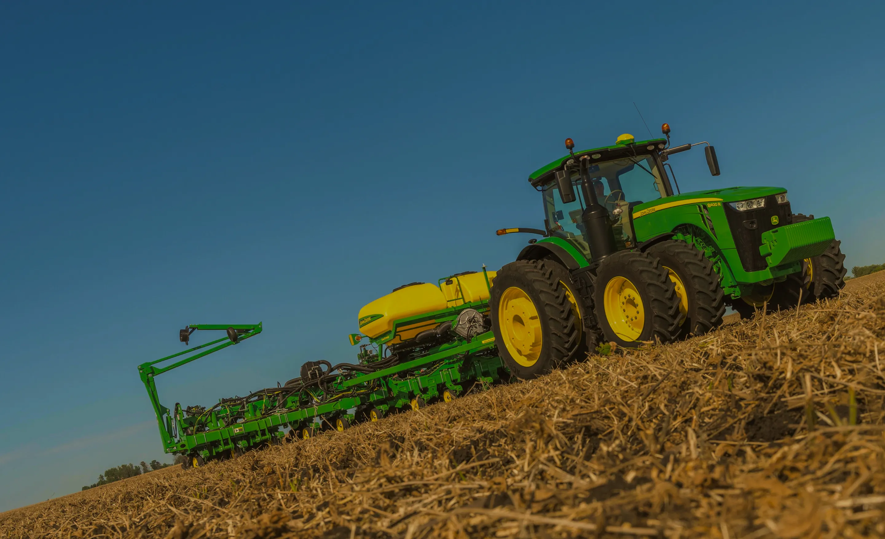 Tractor John Deere con sembradora trabajando en un lote
